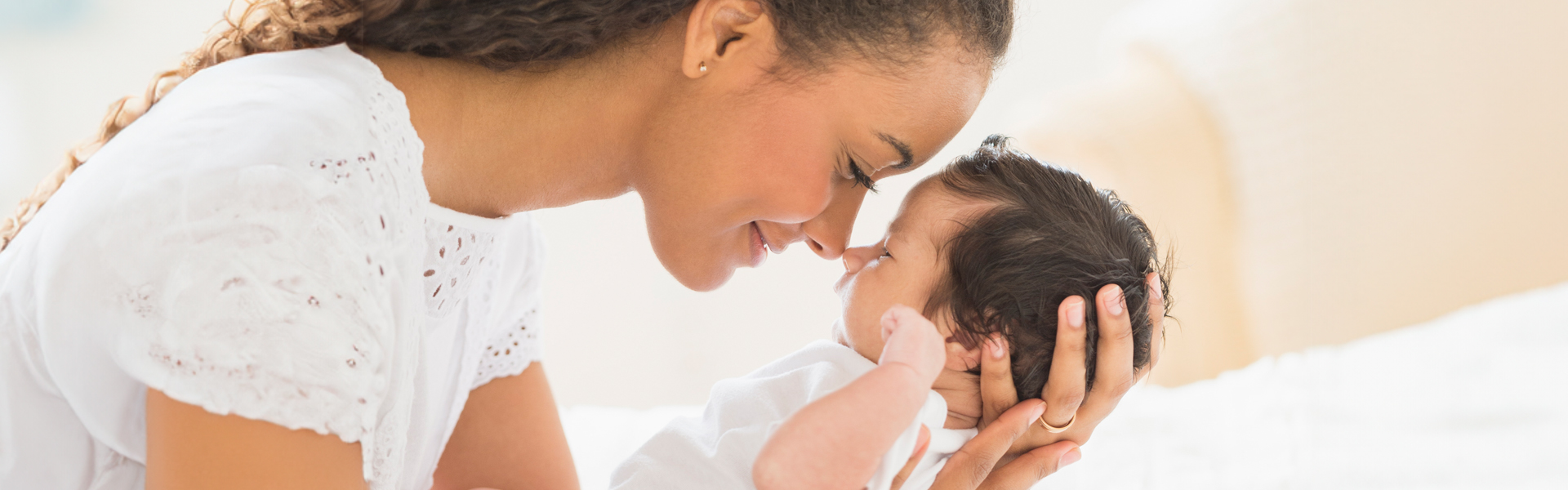 smiling mom holding a newborn baby with lots of hair