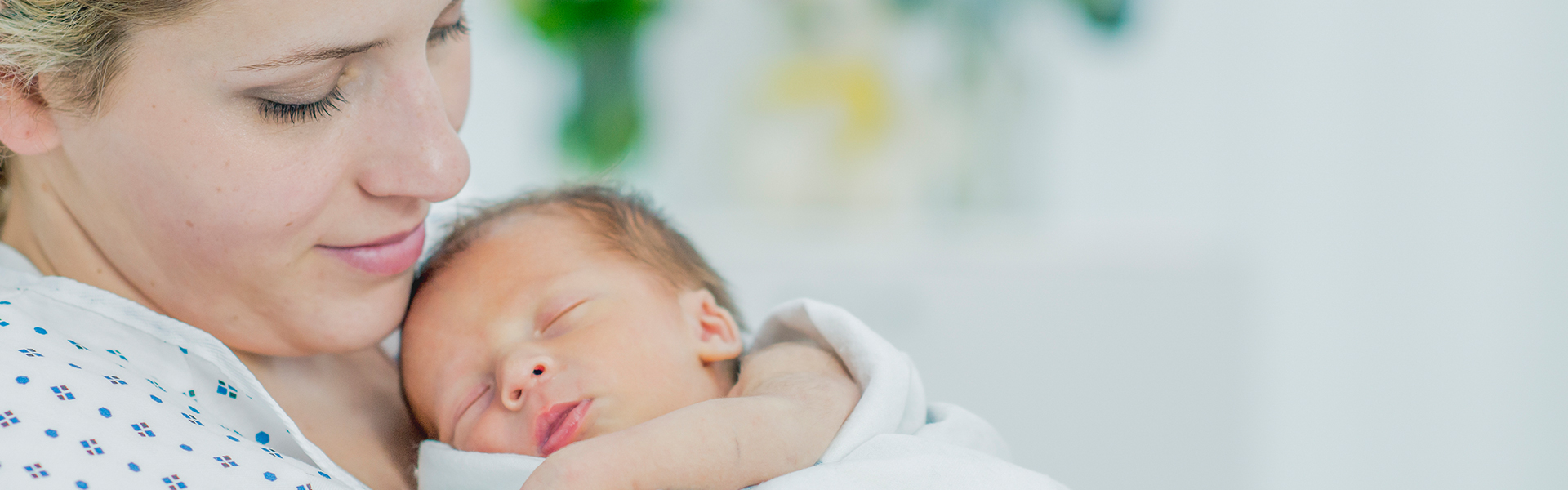 smiling mom looking at newborn baby