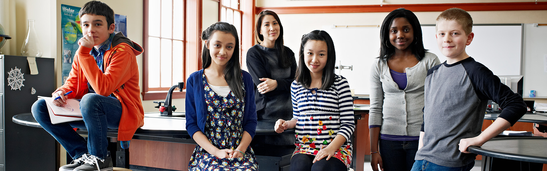 middle school kids and a teacher standing in a science classroom