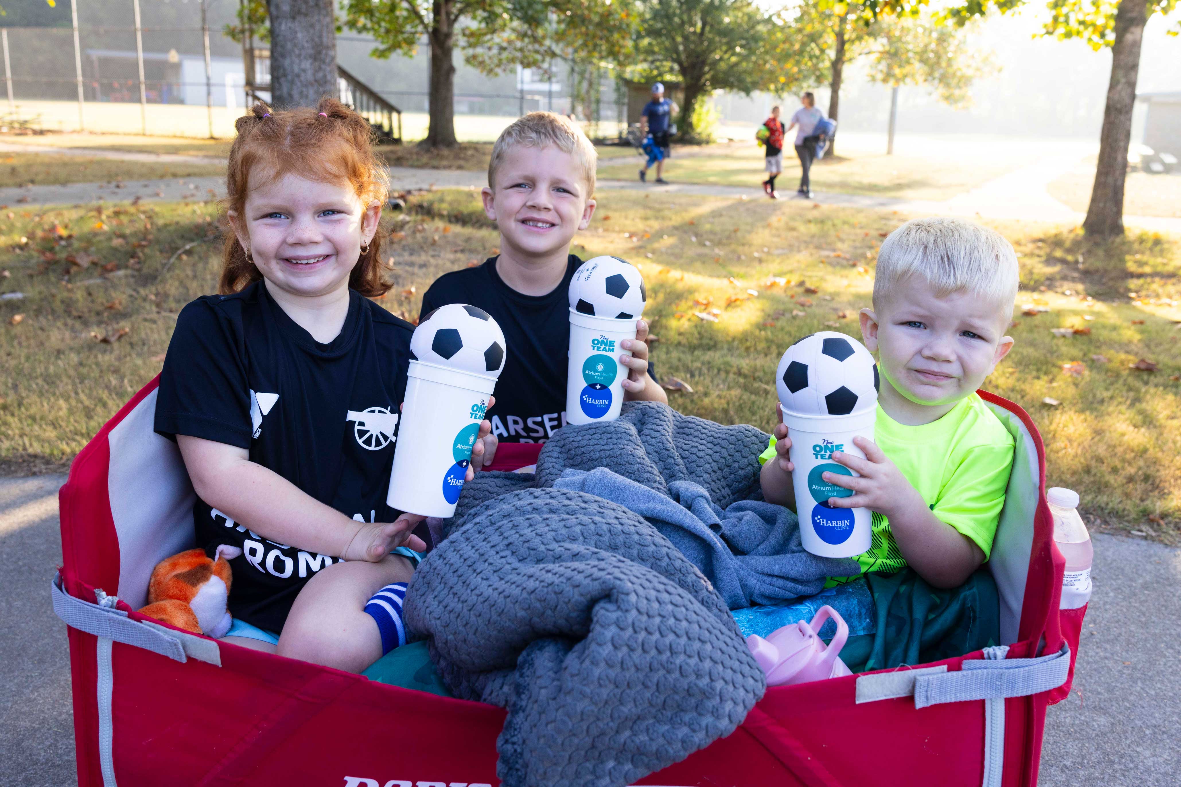 kids in a wagon holding Harbin and Floyd promo items