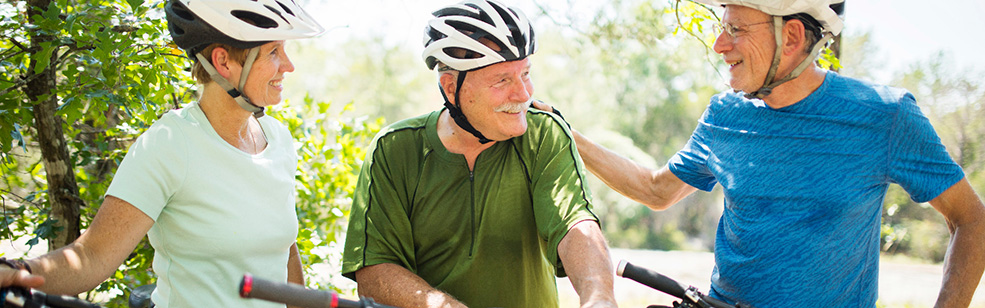 three bicyclists wearing helmets and talking